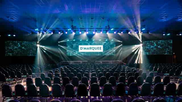 Theater-style D'Marquee stage with LED backdrop for corporate plenary and keynote events.