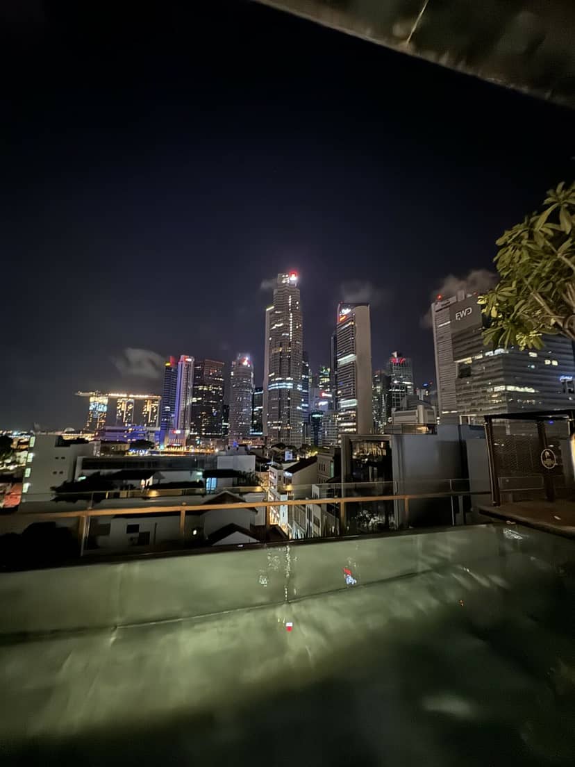 VIP networking at 21 Carpenter rooftop infinity pool with iconic Singapore skyline backdrop.