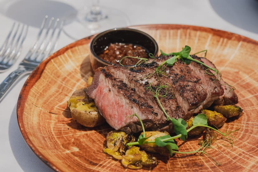 Seared steak entrée at FIRE 1-Atico, premium corporate gala dining.