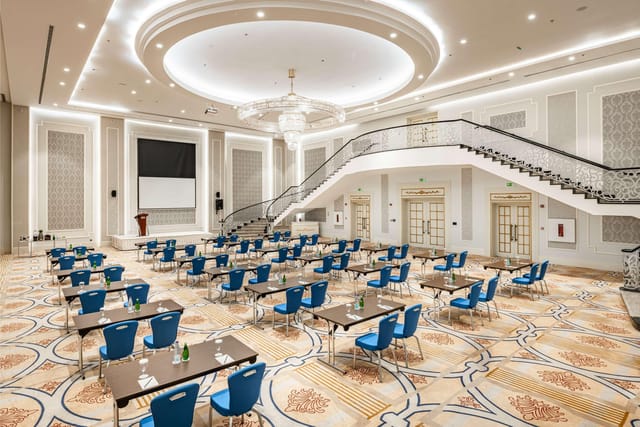 Classroom-style ballroom at Radisson Blu Jeddah with grand staircase for corporate conferences.