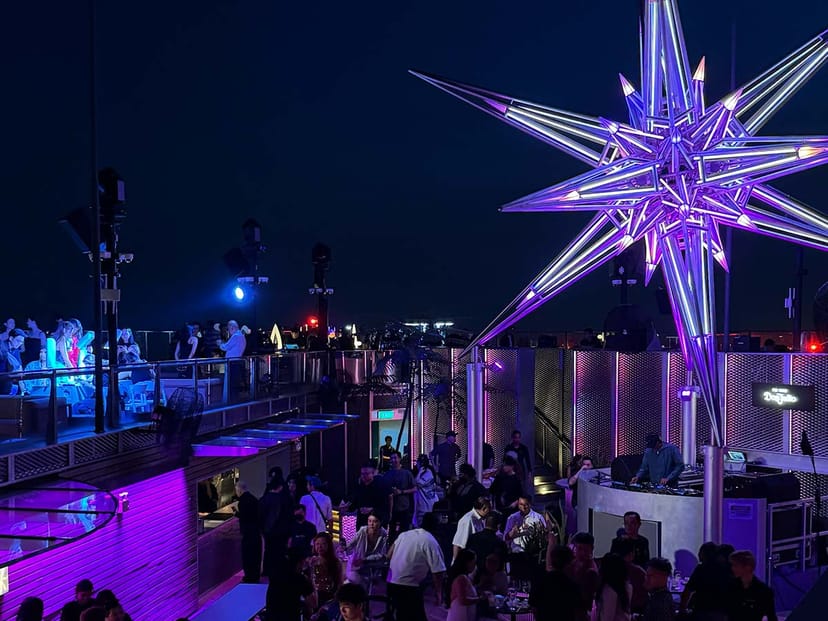 Rooftop networking reception in NOVA with atmospheric lighting and branded focal point installation.