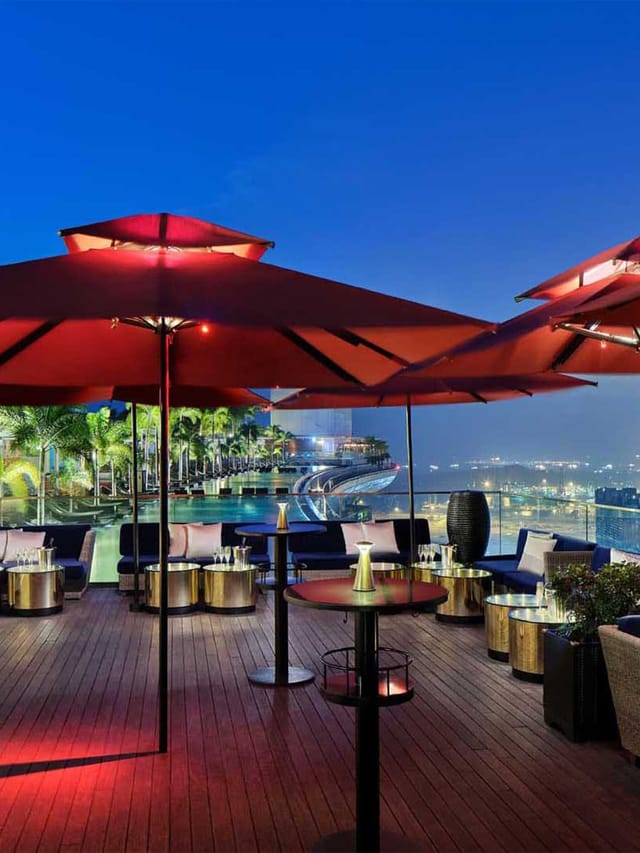 Rooftop Restaurant in CÉ LA VI Singapore with red umbrellas, ideal for upscale events.