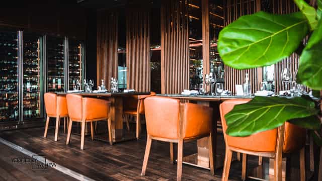 Private dining room at CÉ LA VI Singapore with elegant orange chairs for corporate events.