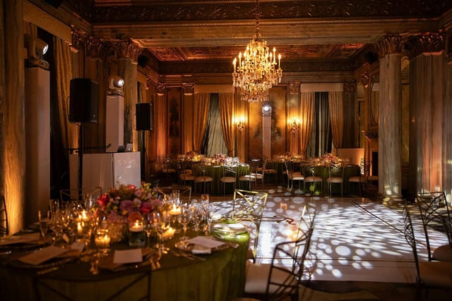 Elegant gala ballroom with floral centerpieces and dramatic dance floor lighting for event venues.