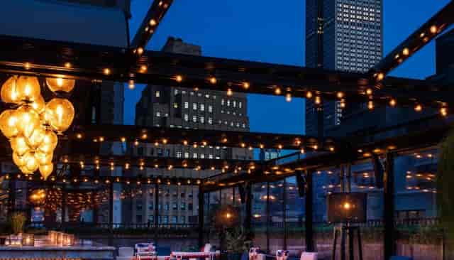 Moxy Times Square rooftop bar with string lights for corporate networking and premium events.