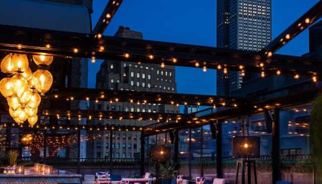 Moxy Times Square rooftop bar with string lights for corporate networking and premium events.