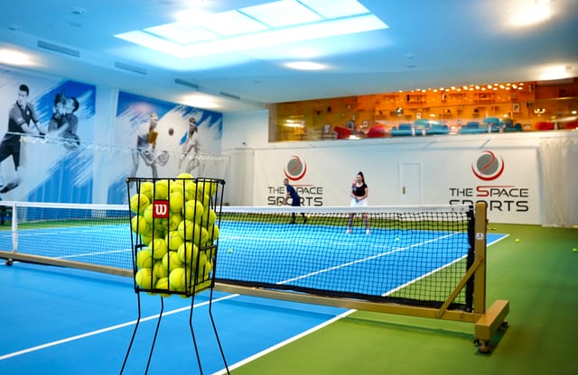Indoor tennis facility with mezzanine lounge for corporate retreats and team building events.