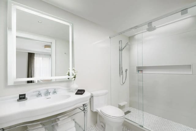 Modern renovated hotel guest bathroom in The Wallace Sterling Room for corporate event room blocks.