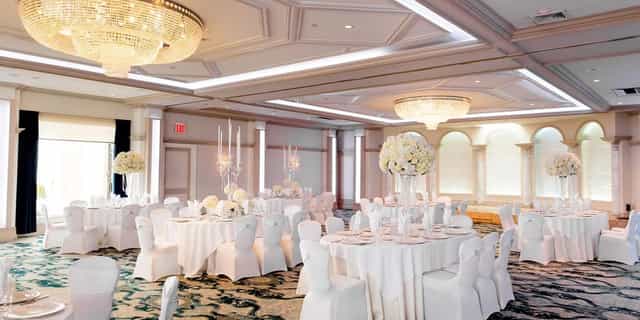 Upscale ballroom event setup with floral centerpieces for a luxury gala or wedding reception.