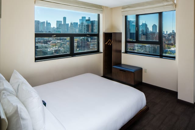 Minimalist Orchard Street Hotel rooftop room with city view for event lodging and corporate stays.