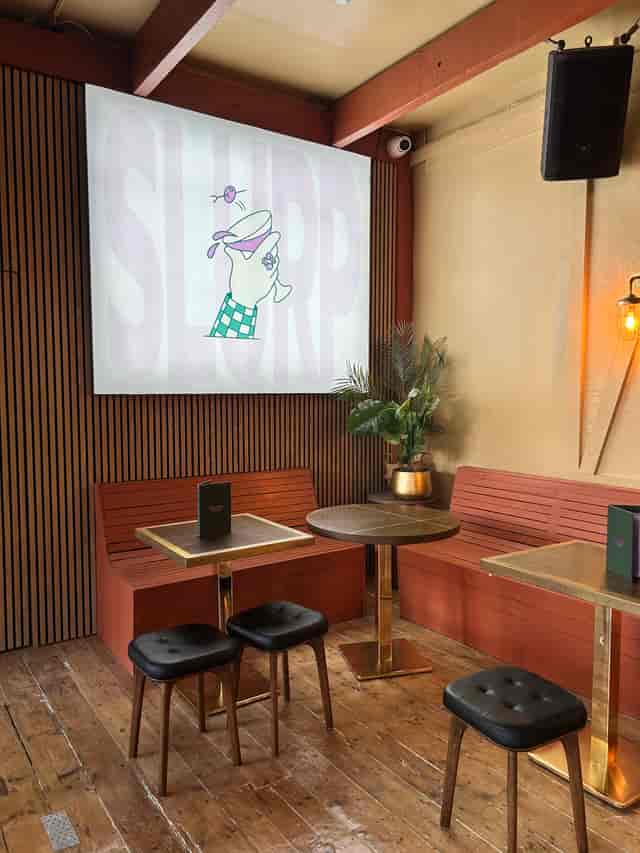Cozy meeting space with booth seating in Shuffle Club for casual events.