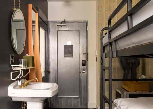 Minimalist bunk bed guest room in Ace Hotel New York for budget group accommodation.