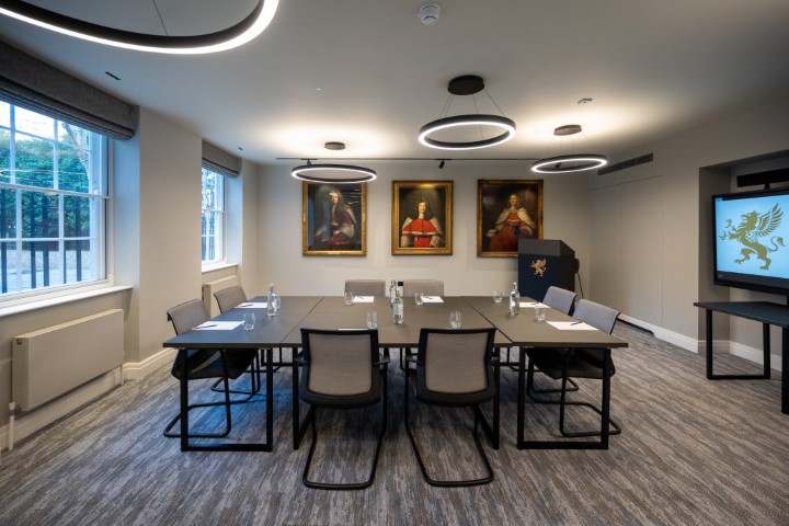 Modern meeting room at The Holt, featuring a large table for professional gatherings. - Banner