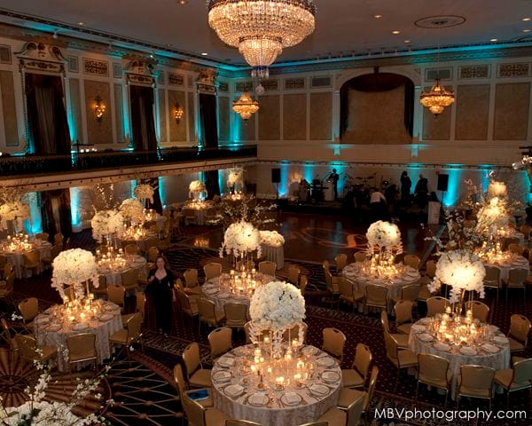 Elegant Roosevelt Hotel ballroom for gala or corporate event with tall floral centerpieces.