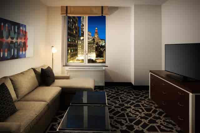 Hilton Brooklyn hotel suite with cityscape view for VIP accommodations and corporate breakout sessions.