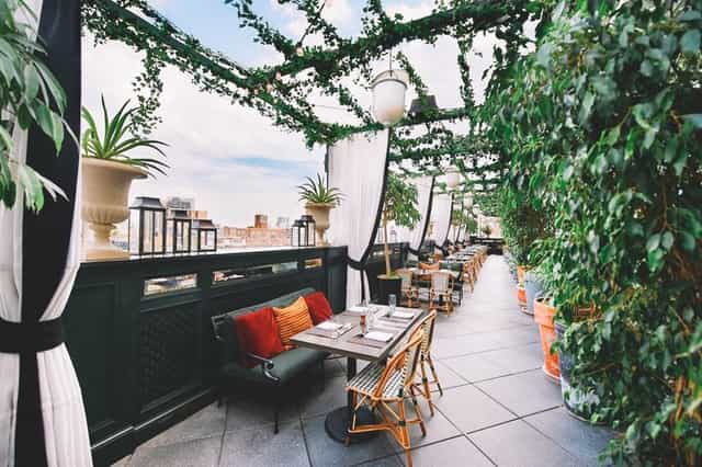 Lush rooftop terrace with garden decor, perfect for upscale corporate events and networking.