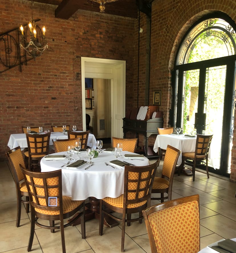 Rustic-chic dining room with exposed brick, perfect for corporate events and rehearsal dinners.