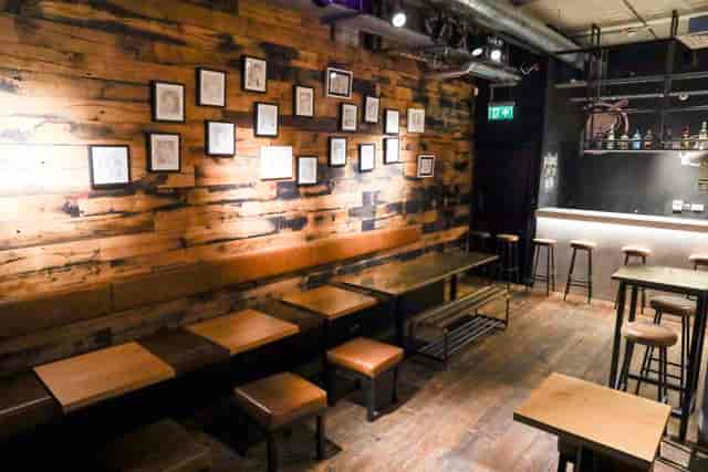 Rustic-industrial basement bar venue for small-group networking and informal receptions.