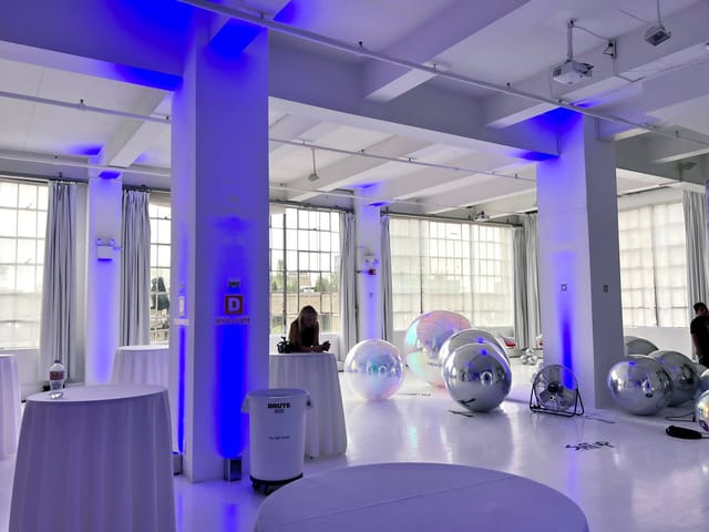 Loft 10 industrial event space with blue uplighting for modern corporate event or wedding venue.