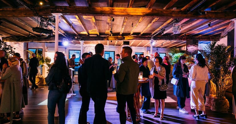 Industrial-chic networking reception with high-top tables at Triangle Loft Meatpacking event space.