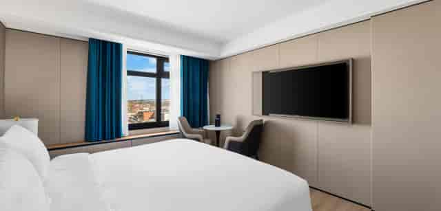 Minimalist LY NY Hotel meeting room with dedicated workspace for business conferences and events.