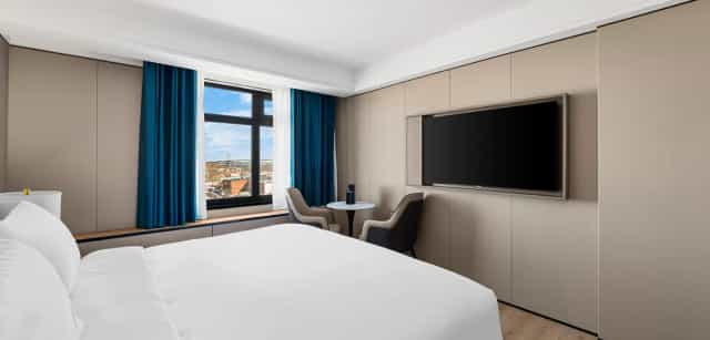 Minimalist LY NY Hotel meeting room with dedicated workspace for business conferences and events.