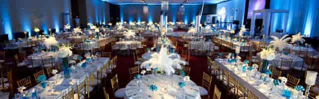 Irving Convention Center ballroom with blue lighting and gold chairs for gala or corporate banquet.