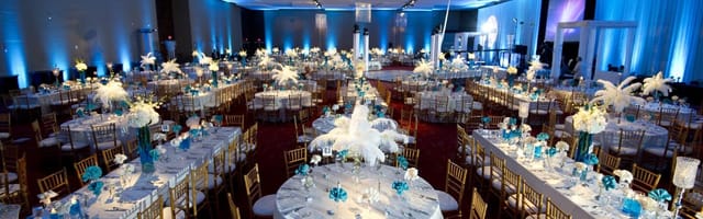 Irving Convention Center ballroom with blue lighting and gold chairs for gala or corporate banquet.