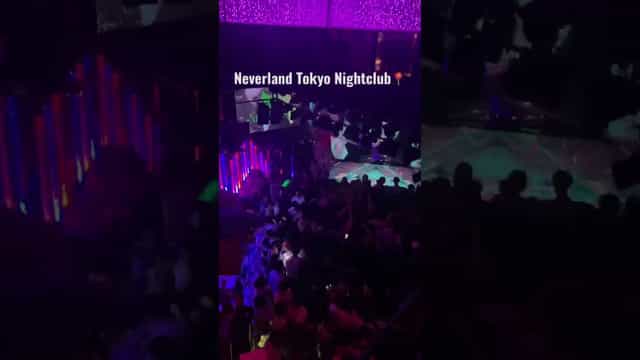 Crowded Club Neverland Tokyo nightclub with vibrant neon lighting for nightlife and club events.