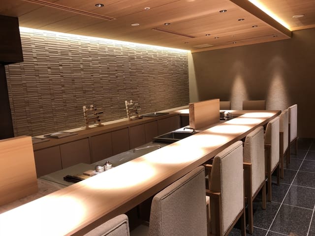Teppanyaki restaurant with linear table and ambient lighting for VIP networking and strategy events.