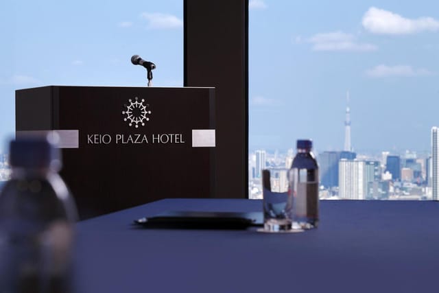 Kagari, Keio Plaza Hotel: Branded lectern against skyline for executive presentations.