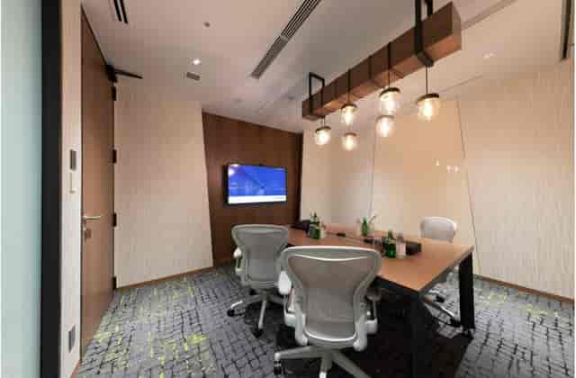 Professional huddle room at Meguro Arco Tower with ergonomic seating for client meetings.