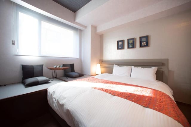Modern Nishijin Suite hotel room with workspace for business travel and remote work.