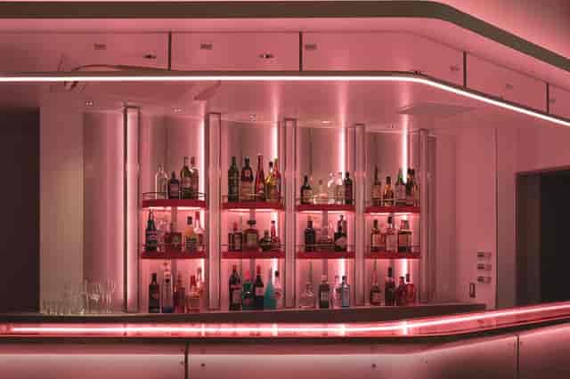 Modern neon-lit BnA Hotel bar, ideal for high-end corporate evening reception networking events.