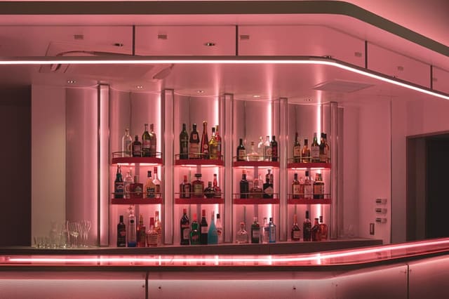 Modern neon-lit BnA Hotel bar, ideal for high-end corporate evening reception networking events.