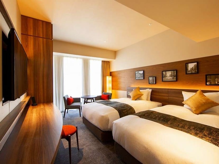 Modern twin hotel room at karaksa Ginza for corporate travel and business conferences.