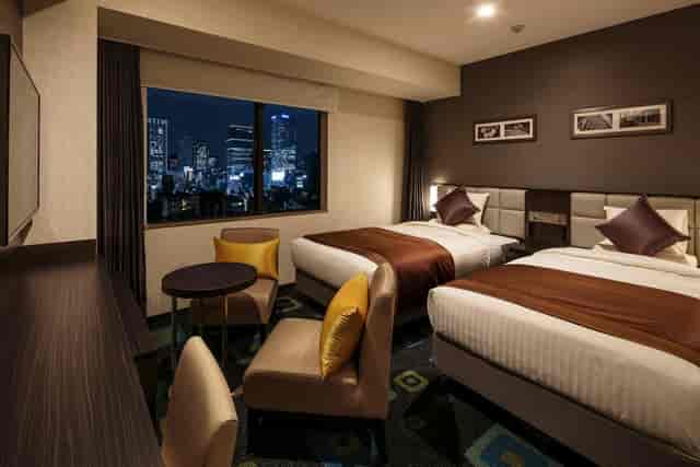 Twin-share business hotel room with city view, ideal for corporate event lodging.