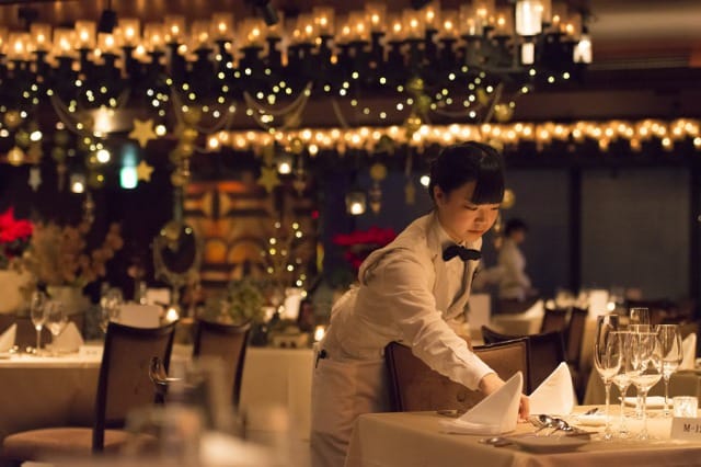 Server setting tables at TANGO Terrace for an upscale gala or banquet event.