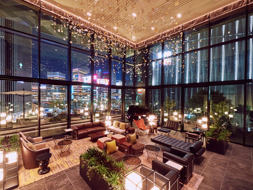 Glass-walled event lounge at THE GATE HOTEL for VIP networking and cocktail receptions.