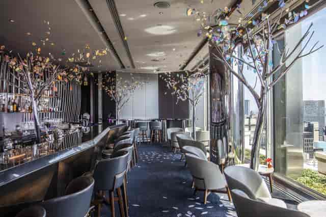 Upscale cocktail bar with floor-to-ceiling windows for VIP networking and corporate event venues.
