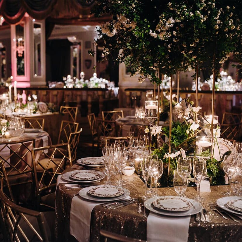 Luxury gala wedding setup in Rosette Room with tiered floral centerpieces and gold chairs.