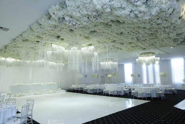 Floral ceiling installation over a white dance floor for luxury gala and wedding event design.