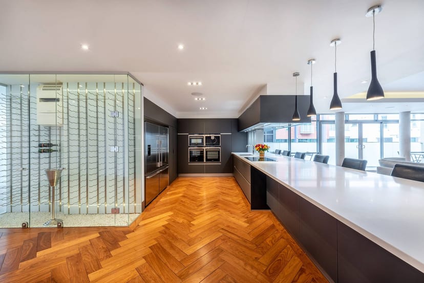 Lumiere London Apartment: Glass wine display for private chef workshop or culinary event.