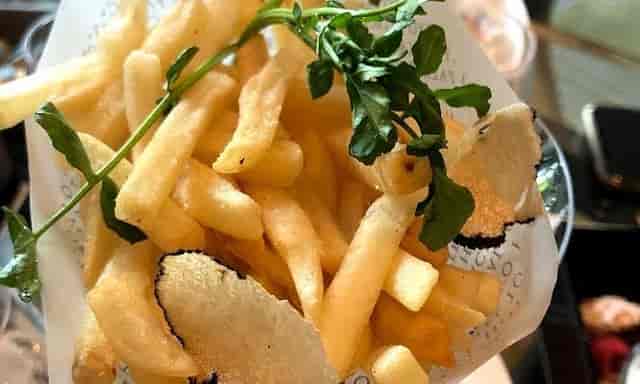 Truffle fries in branded paper at a Lounge Bar Privé cocktail reception for event catering.