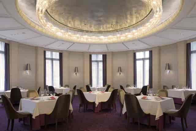 Circular banquet room at Restaurant Blanc Rouge with statement chandelier for VIP networking events.