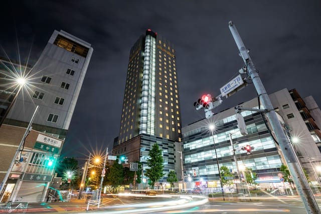 Hundred Stay Tokyo Shinjuku high-rise hotel at night for corporate travel and business meetings.