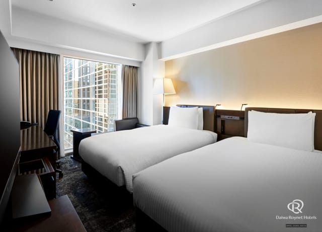Modern twin room at Bellesalle Shinjuku Central Park with workspace for business travel events.