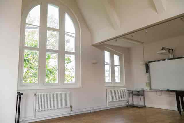Bright meeting space with arched windows, perfect for workshops and events.