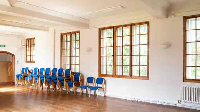 Spacious lecture room with blue chairs, perfect for workshops and gatherings.
