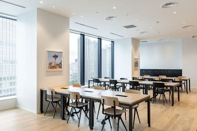 Sleek Tokyo Teleport coworking training room with modular wood tables for corporate workshops.